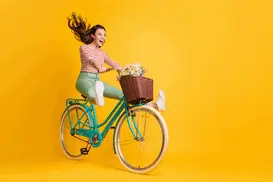 Wesoła i pogodna dziewczyna na rowerze, z koszem kwiatów z przodu. Żyjąc pełnią życia, dobiera studia, które najlepiej współgrają z jej energiczną osobowością!