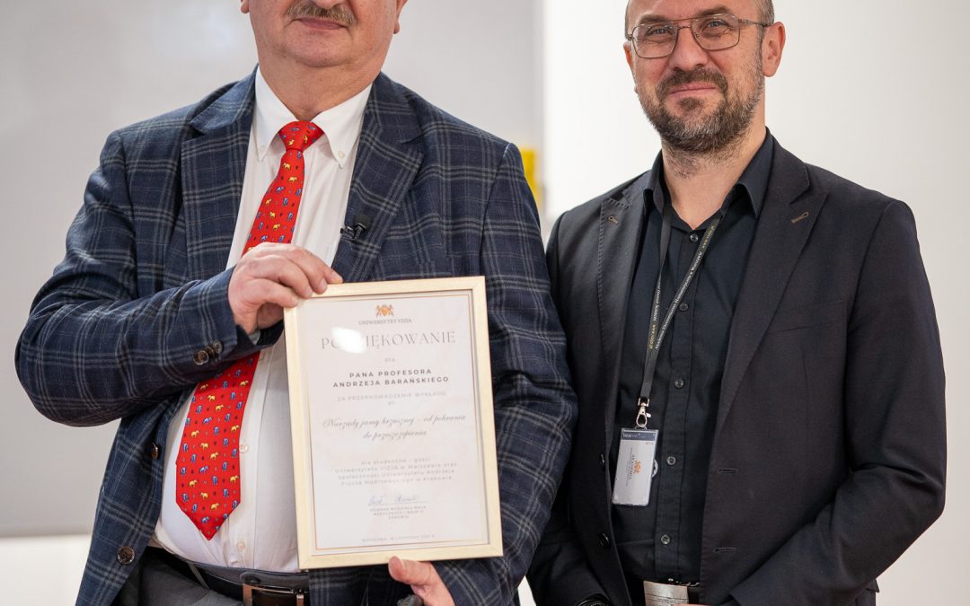 Dziekan wręcza dyplom z podziękowaniem wykłądowcy.