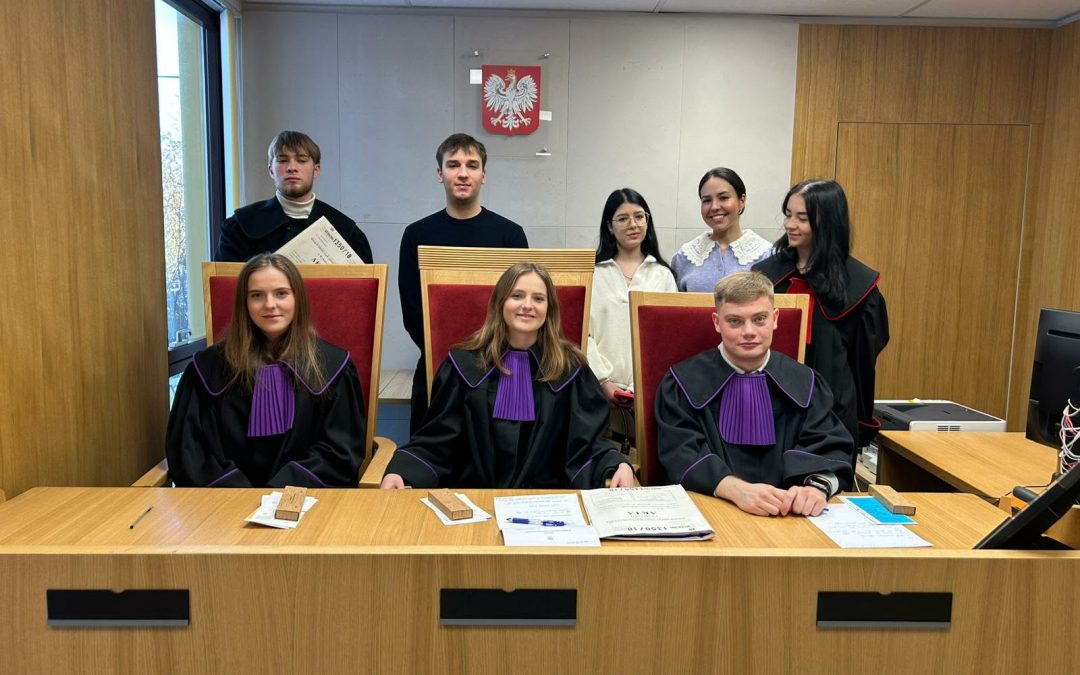studenci prawa na Uniwersytecie VIZJA, stoją w togach na sali sądowej