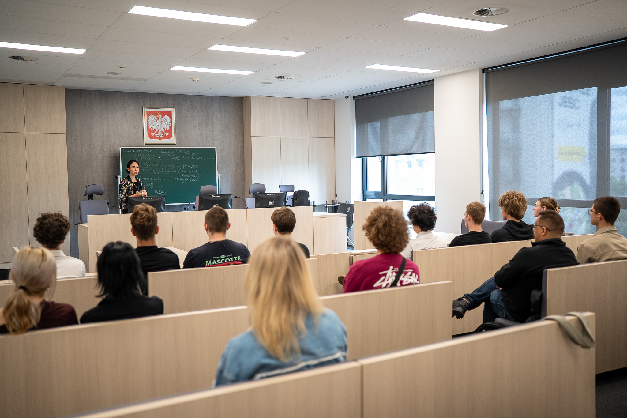 sala sądowa na uniersytecie, uczniowei siedzą w ławach w togach
